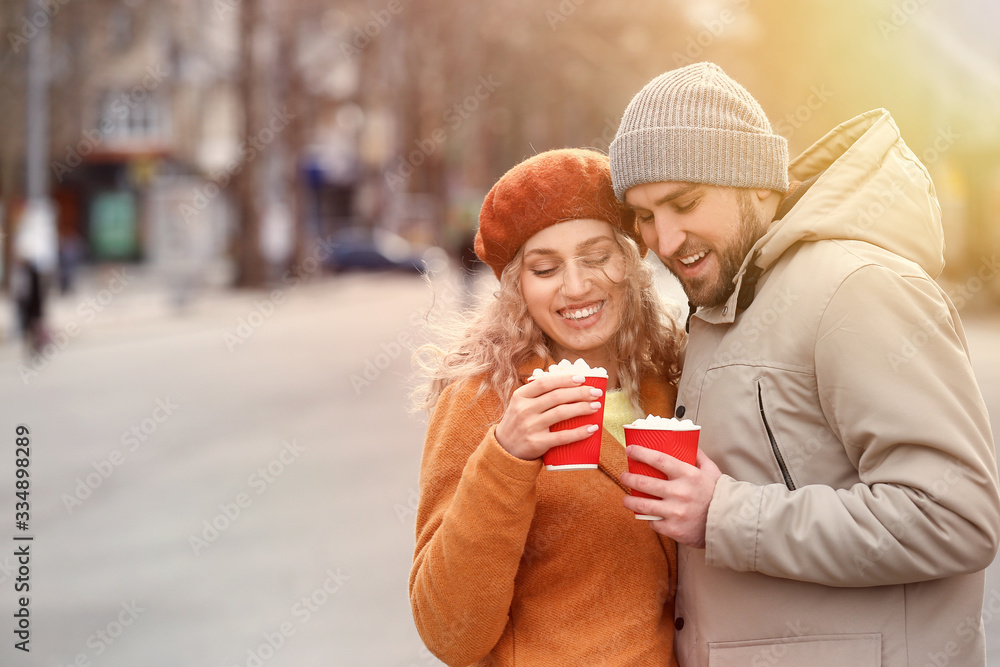 Happy young couple drinking hot cocoa outdoors