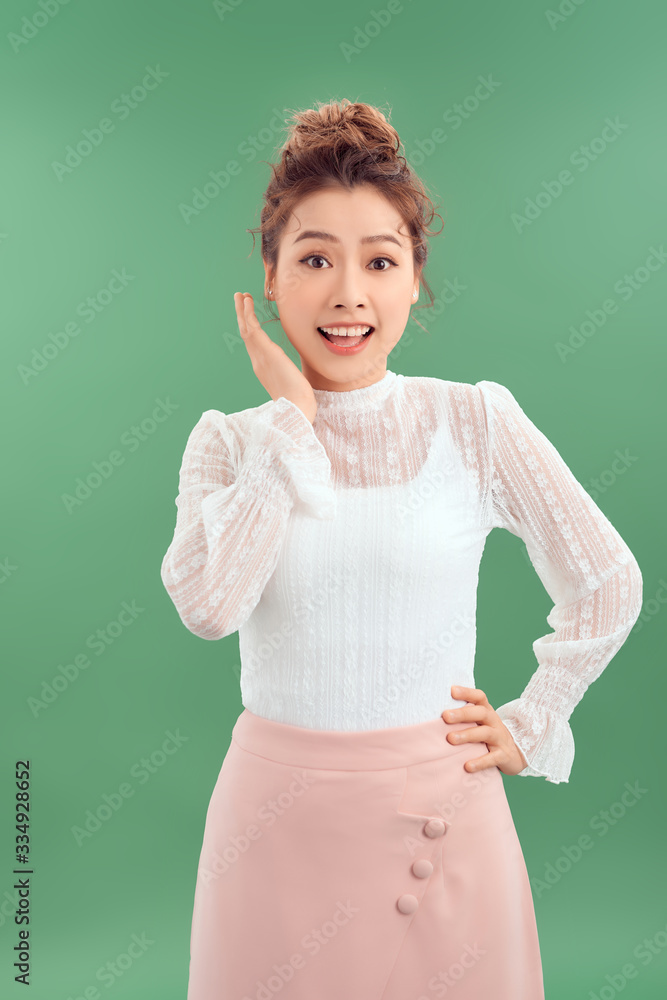 Attrative young Asian woman standing islated over green background.