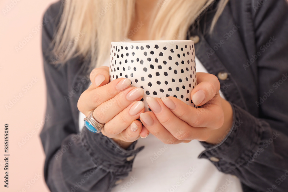 Beautiful young woman with tea on color background, closeup