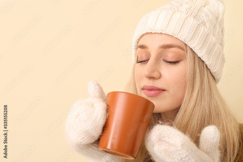 Beautiful young woman with tea on color background