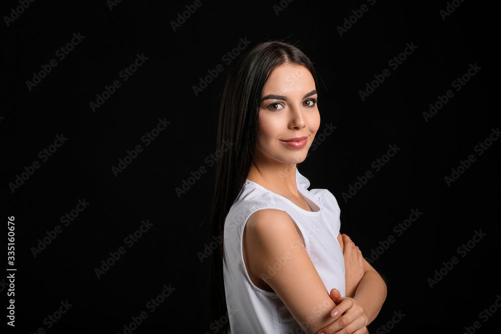 Young woman with beautiful healthy hair on dark background