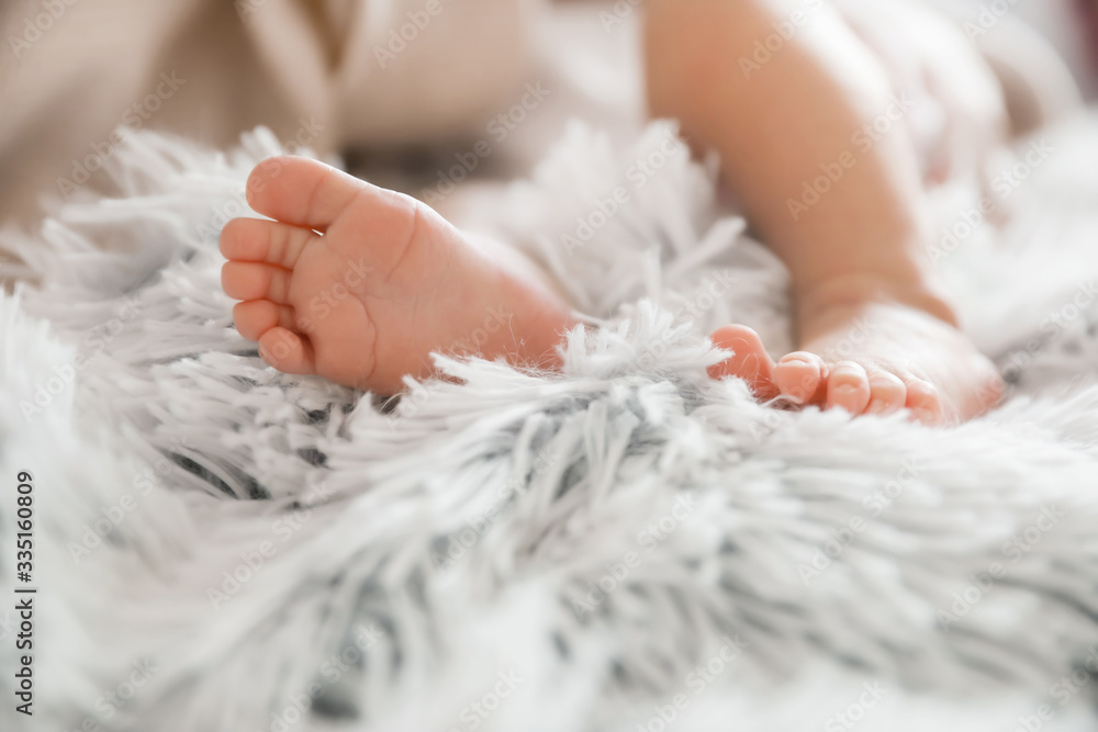 Feet of little baby girl lying on plaid