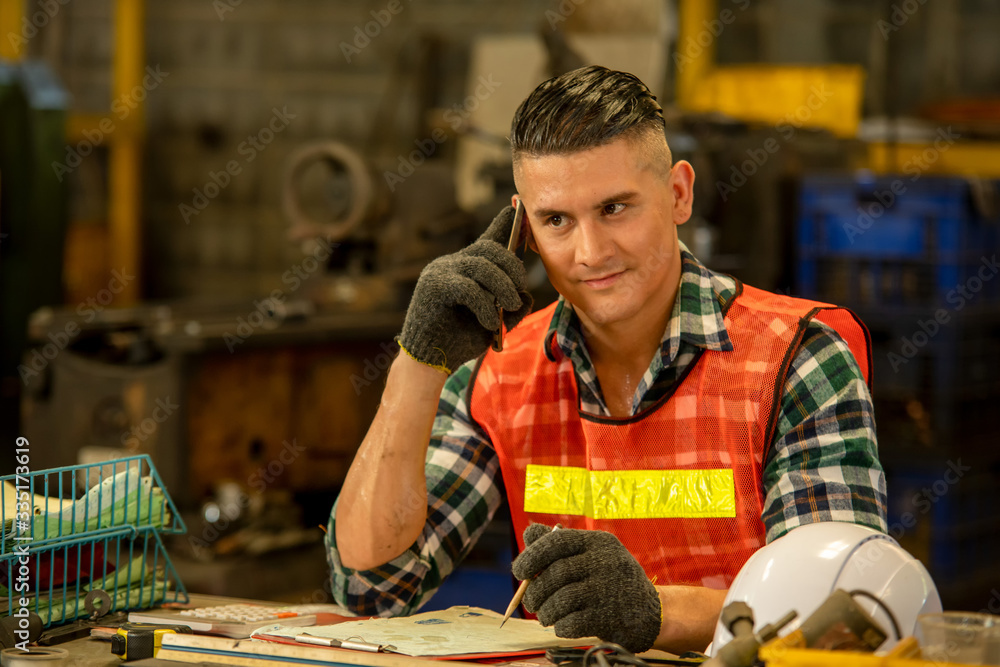 Portrait of engineer using a mobile phone,Smart Engineering talking on phone and working at factory,