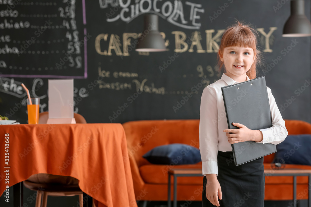 Cute little waiter in restaurant