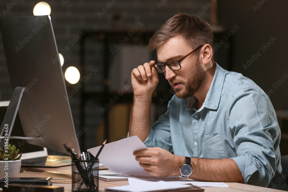 Male programmer working in office at night