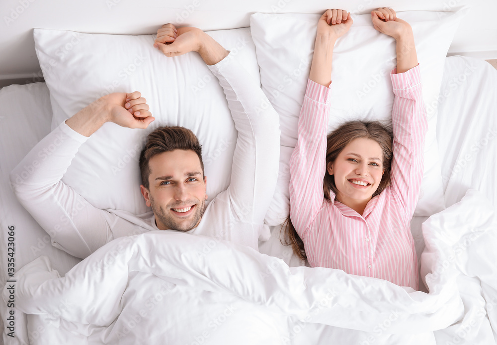 Morning of happy young couple in bed