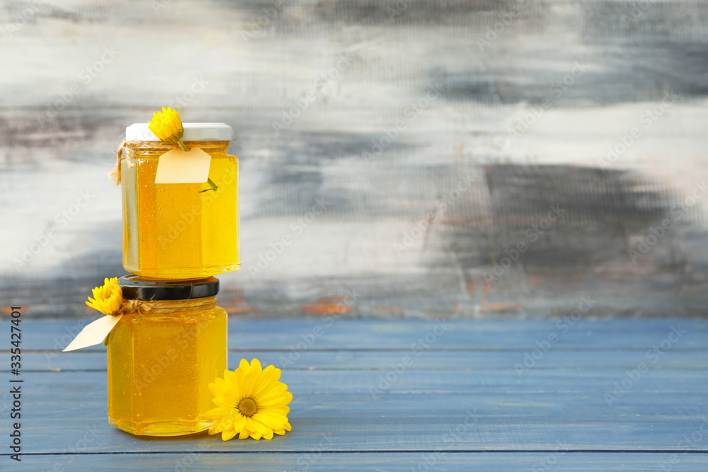 Jars of sweet honey on table