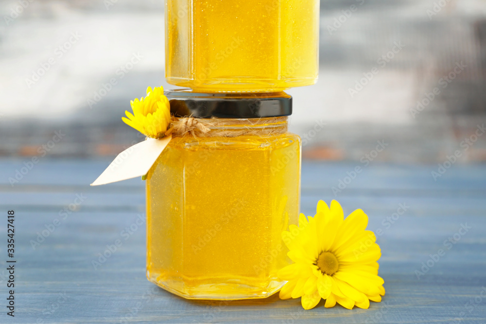 Jars of sweet honey on table