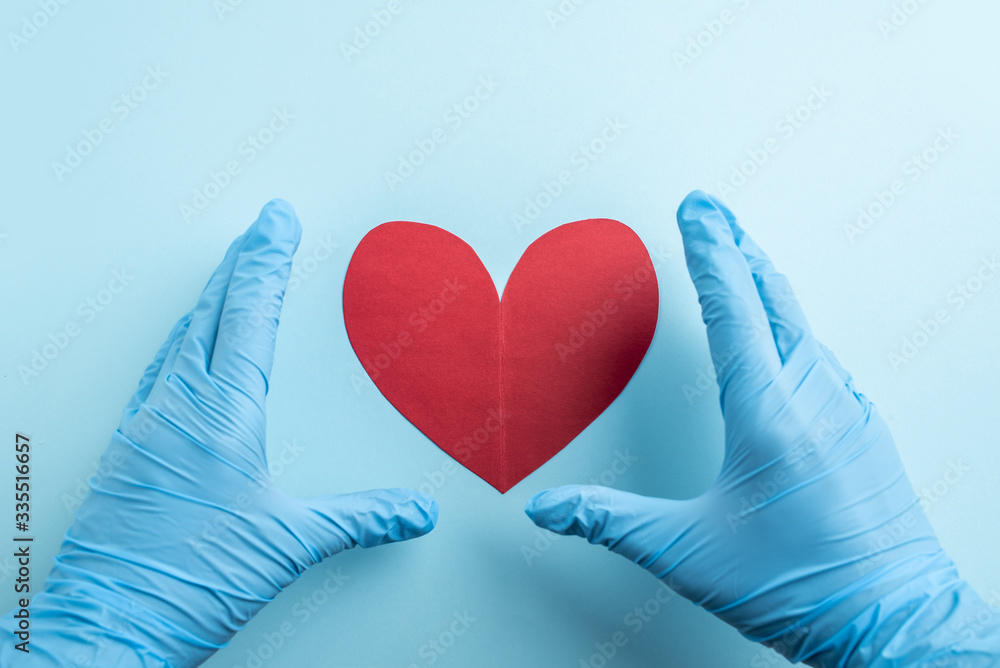 Medical staff holding red hearts in both hands