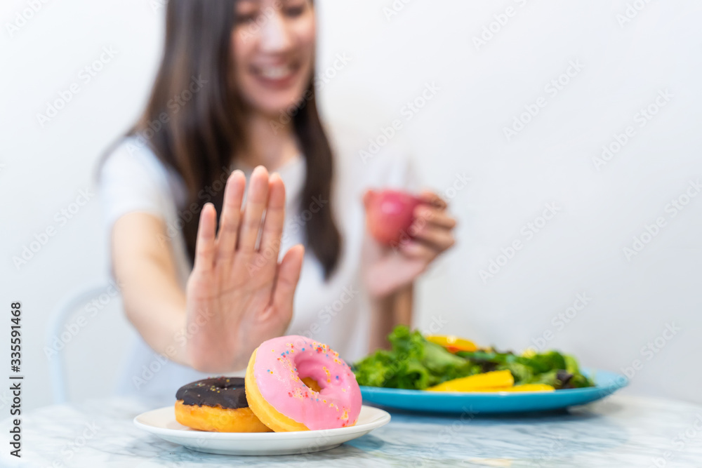 亚洲年轻女性拒绝垃圾食品，而为了健康选择吃健康沙拉和果汁