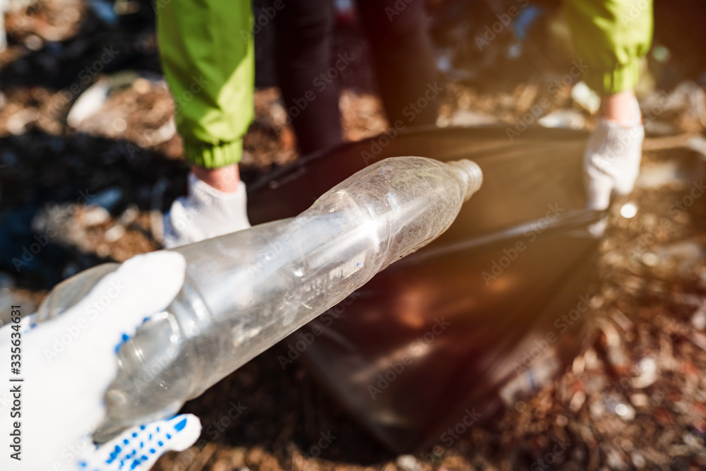 plastic bottle collect garbage into a bag. environmental cleaning