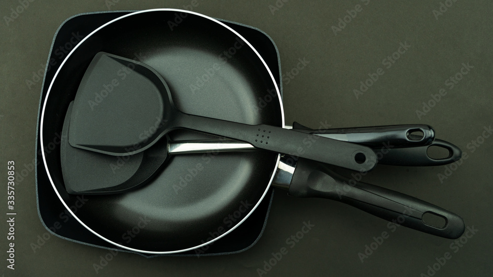 Top view frying pan and pot on black background.