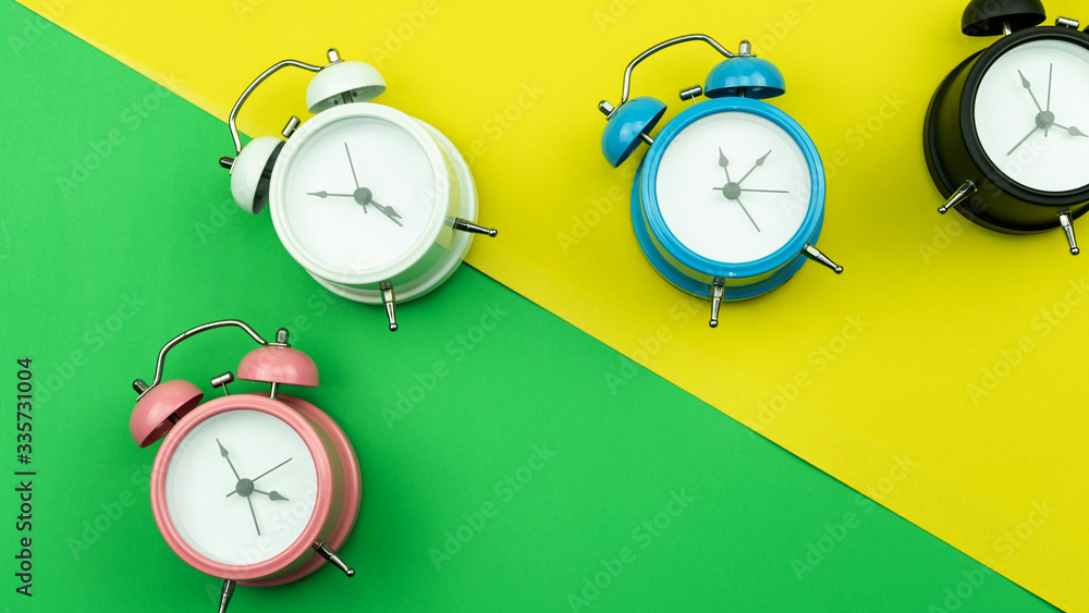 Flat lay retro beautiful new alarm clock on sweet colorful paper pastel color background.