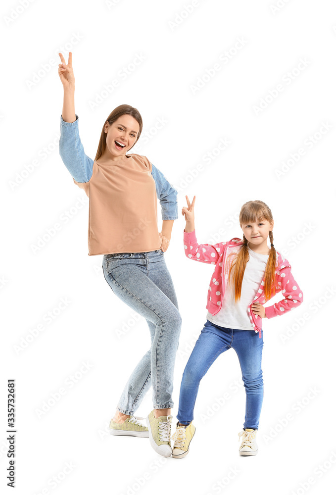 Happy mother and her little daughter dancing against white background