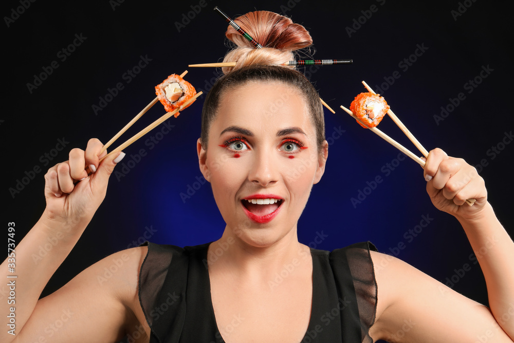 Beautiful woman with tasty sushi on dark background