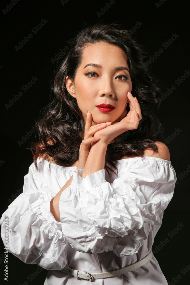 Young Asian woman with beautiful hair on dark background