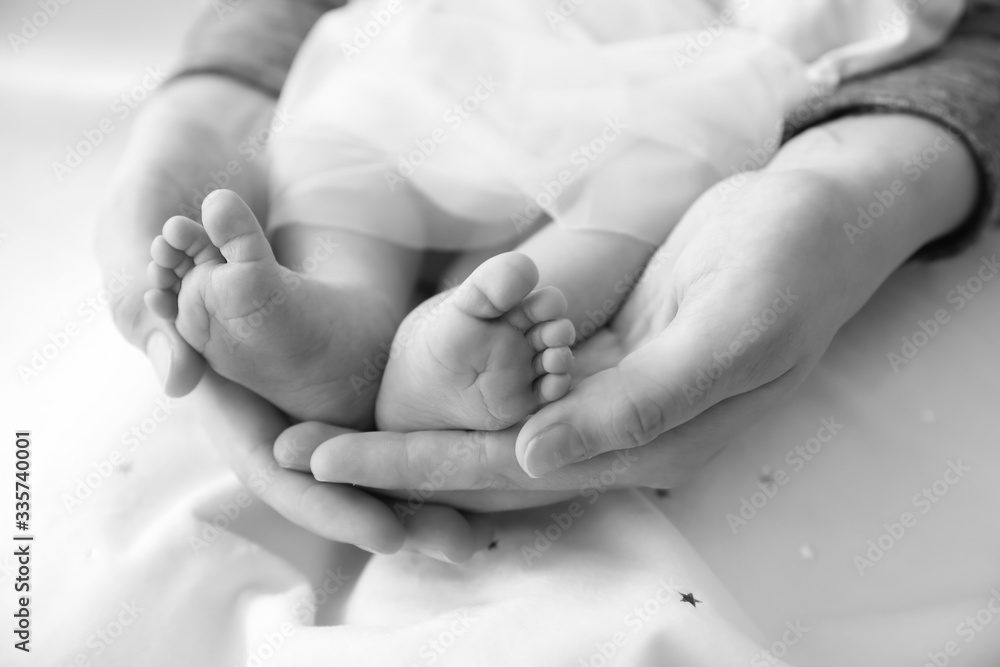 Mothers holding tiny feet of little baby