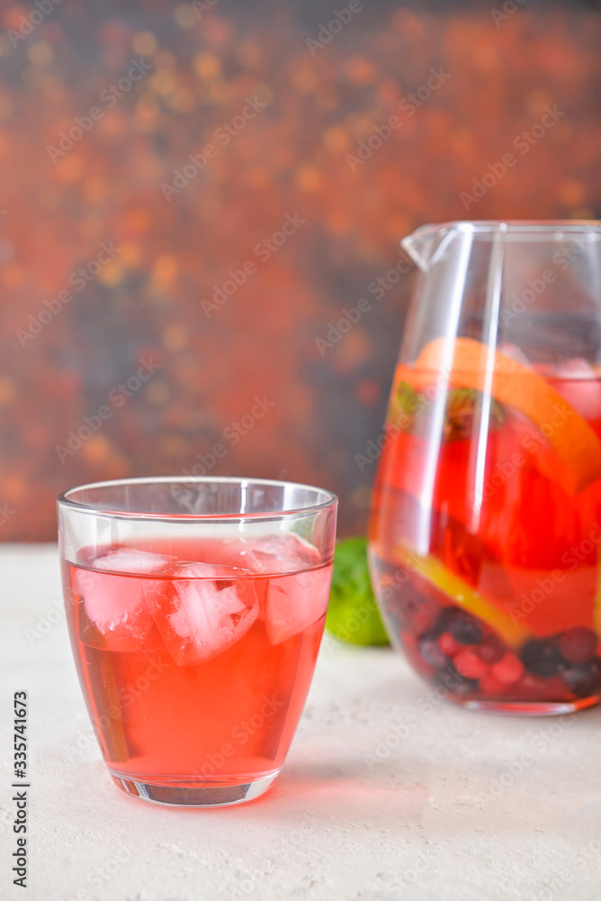 Glass and jug of tasty cold tea on table