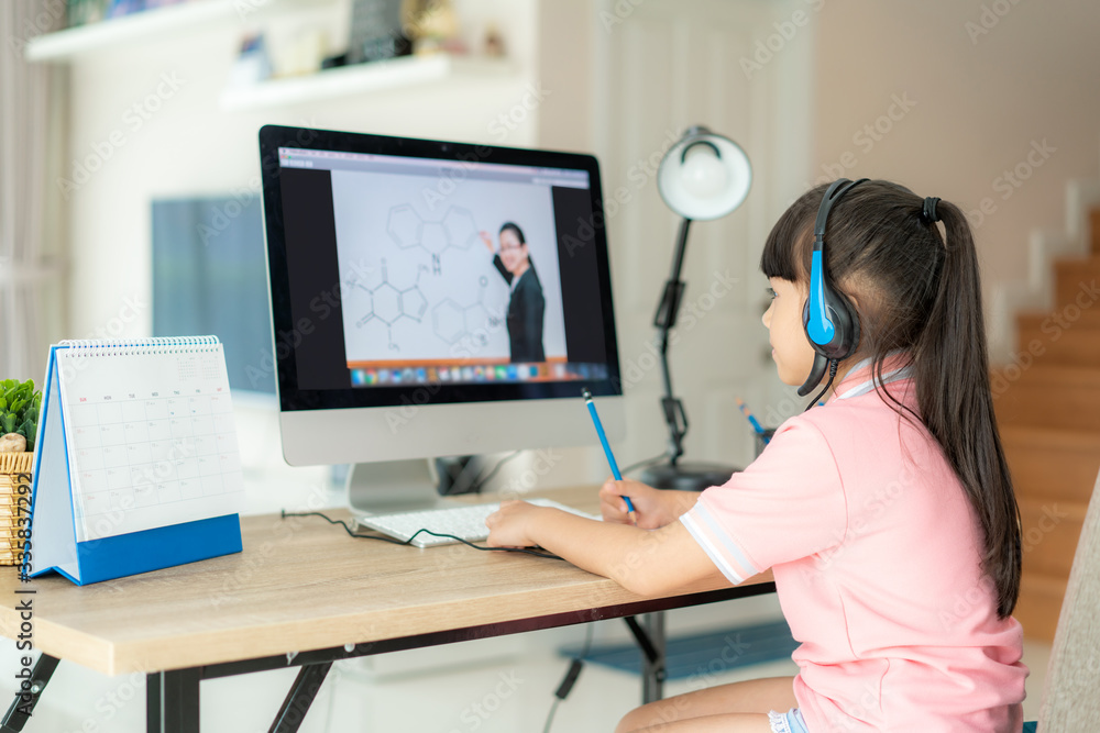 Asian girl student video conference e-learning with teacher on computer in living room at home. Home