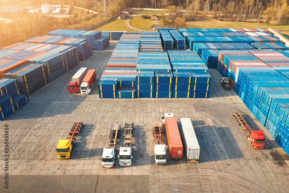 Aerial view of trucks and containers at sunset.  Top view of autotrucks, container warehouse in logi