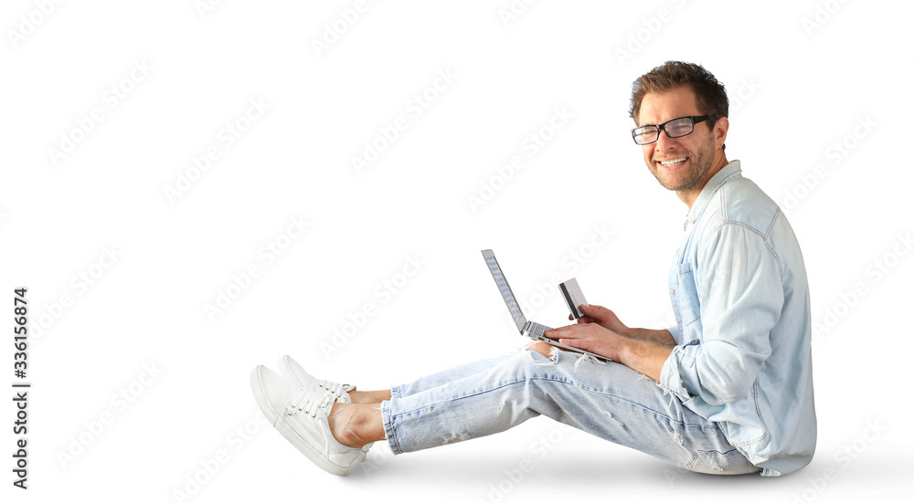 Young man with a laptop and a credit card