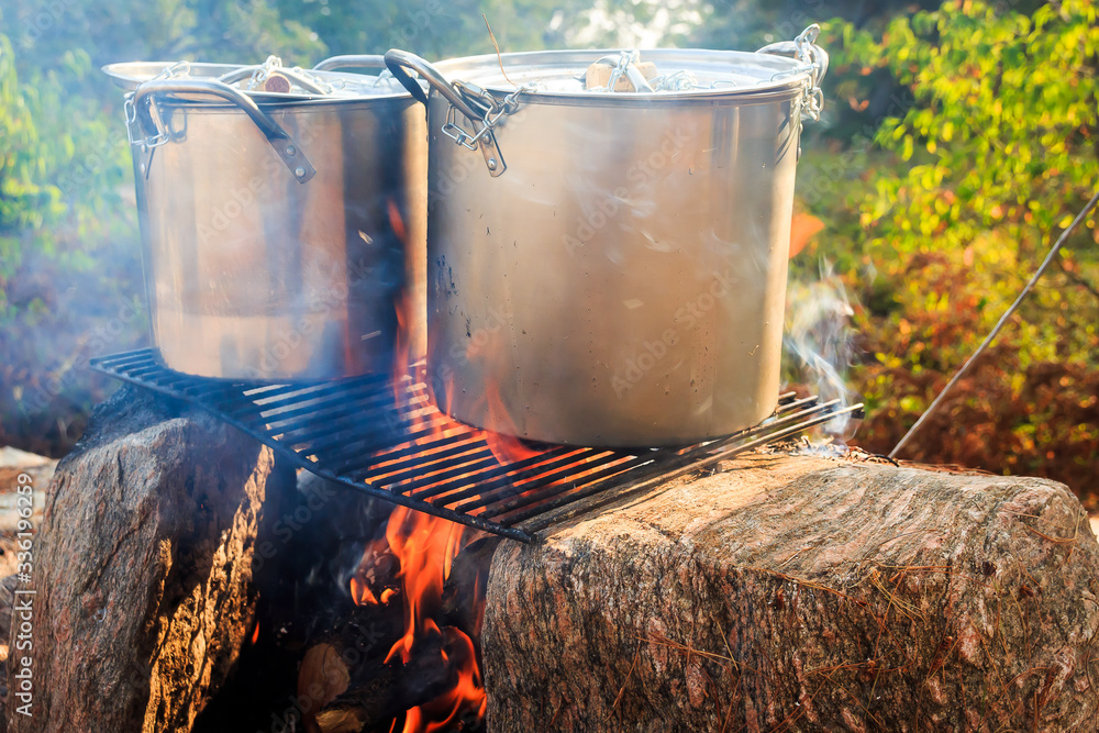 Camping cooking: two pots, fire and stones