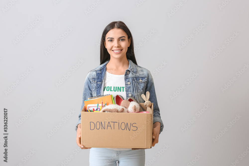 Volunteer with donations for orphans on grey background