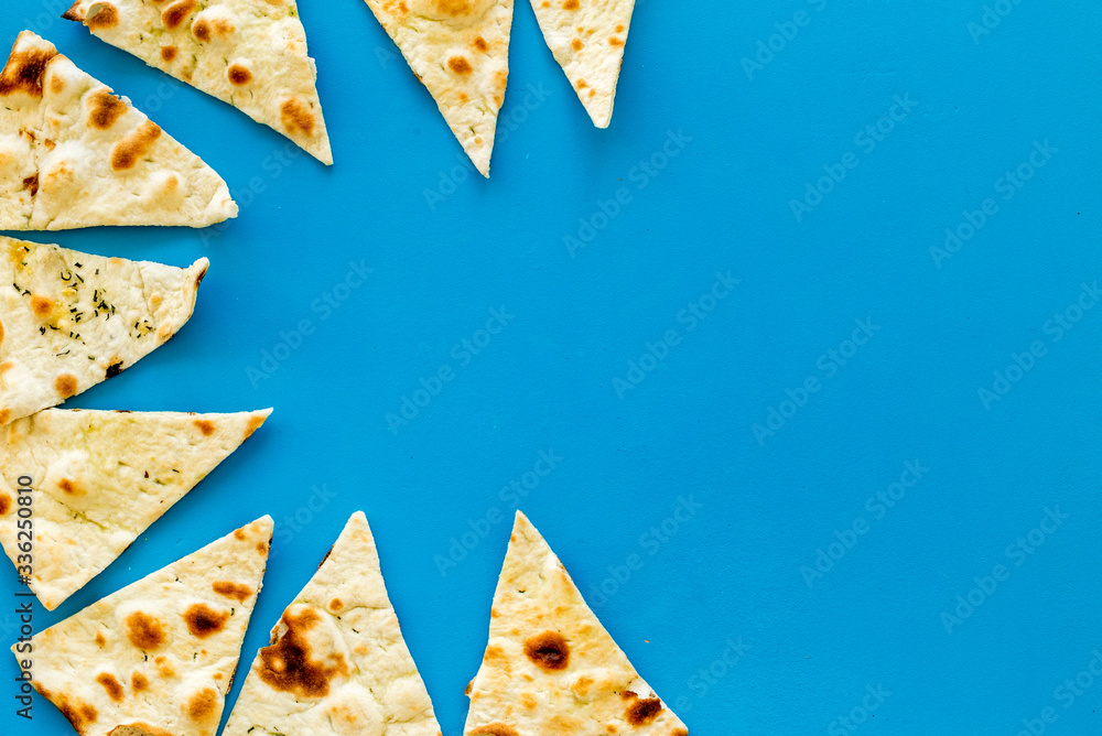 Focaccia pieces frame on blue background top-down copy space