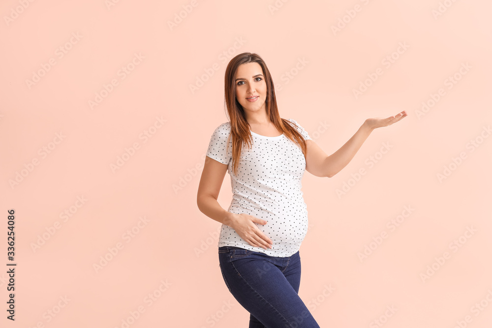 Beautiful pregnant woman on color background