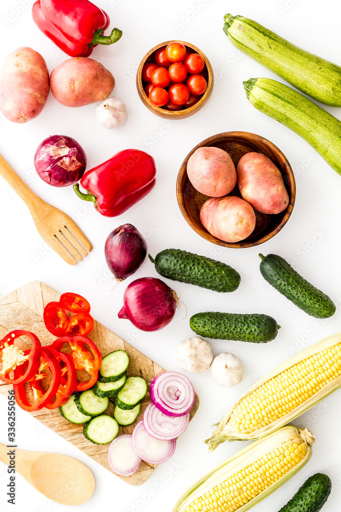 Fresh vegetables still life. Potato, cucumber, beet carrot, greenery on white background top-down