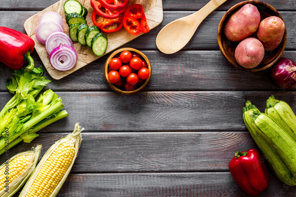 Autumn harvest. Vegetables - potato,cucumber, corn, greenery - frame on dark wooden background top-d