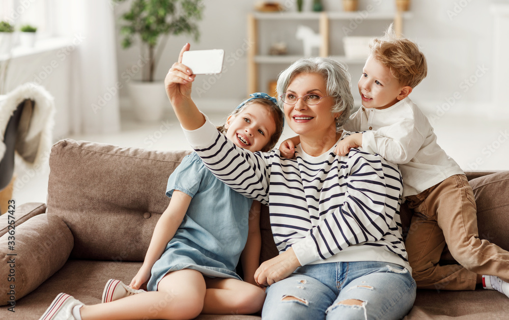 Grandmother taking selfie with grandchildren.