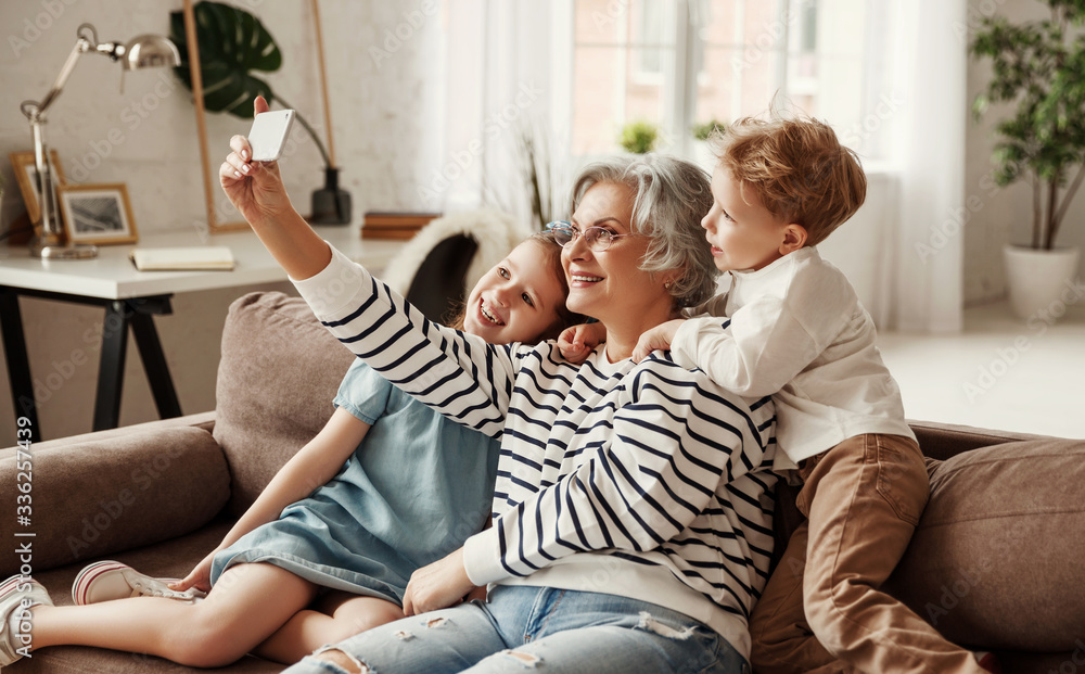 Grandmother taking selfie with grandchildren.