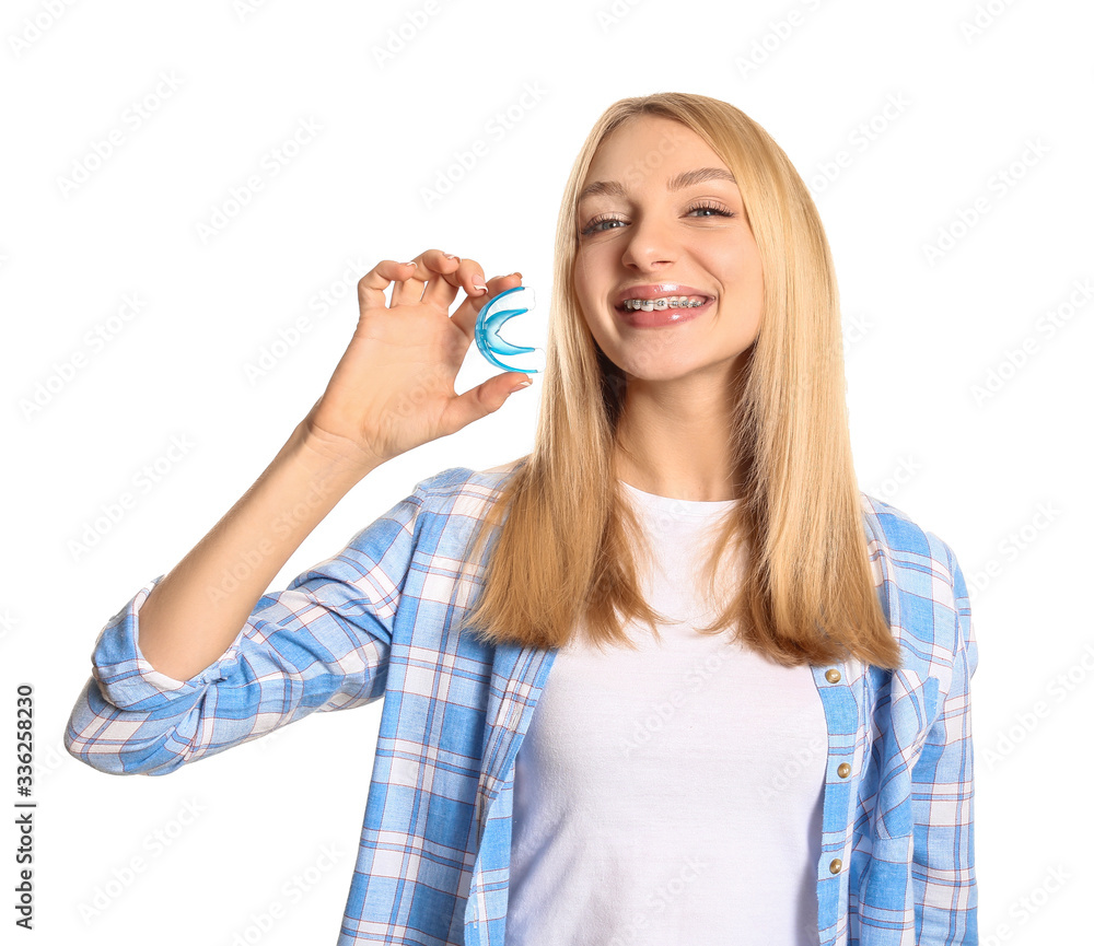 Young woman with dental braces and mouth protector on white background