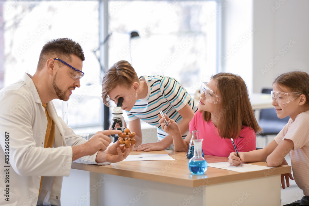 Teacher conducting chemistry lesson in classroom