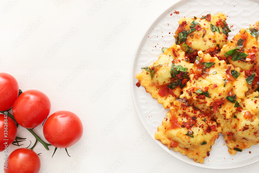 Plate with tasty ravioli on table