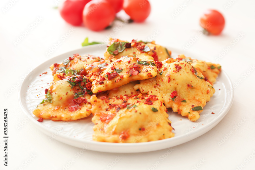 Plate with tasty ravioli on table