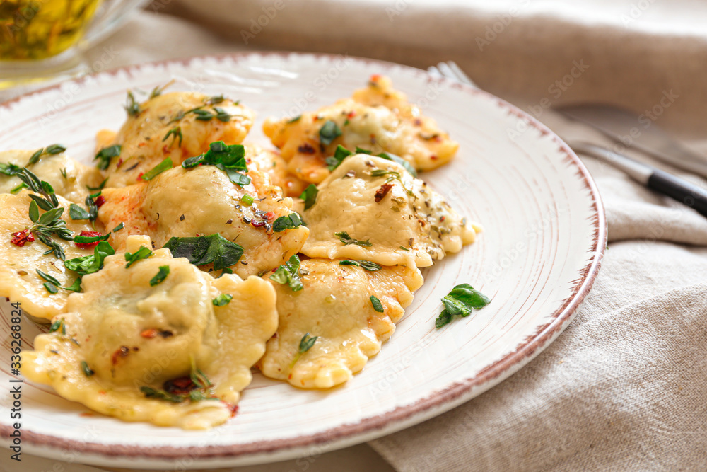 Plate with tasty ravioli on table