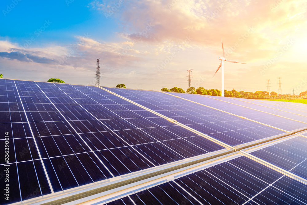 Solar panels with wind turbines in the setting sun,green energy.