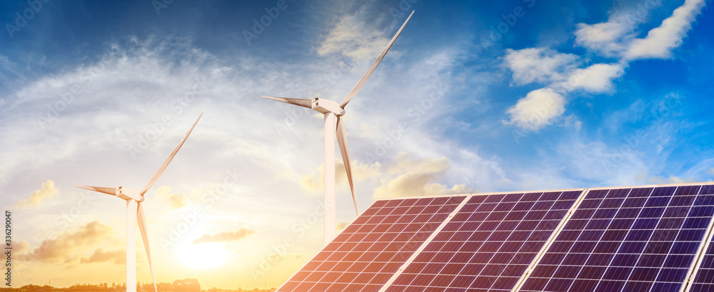 Solar panels with wind turbines in the setting sun,green energy.