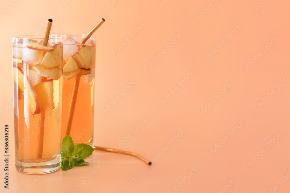 Glasses of tasty cold ice tea on color background