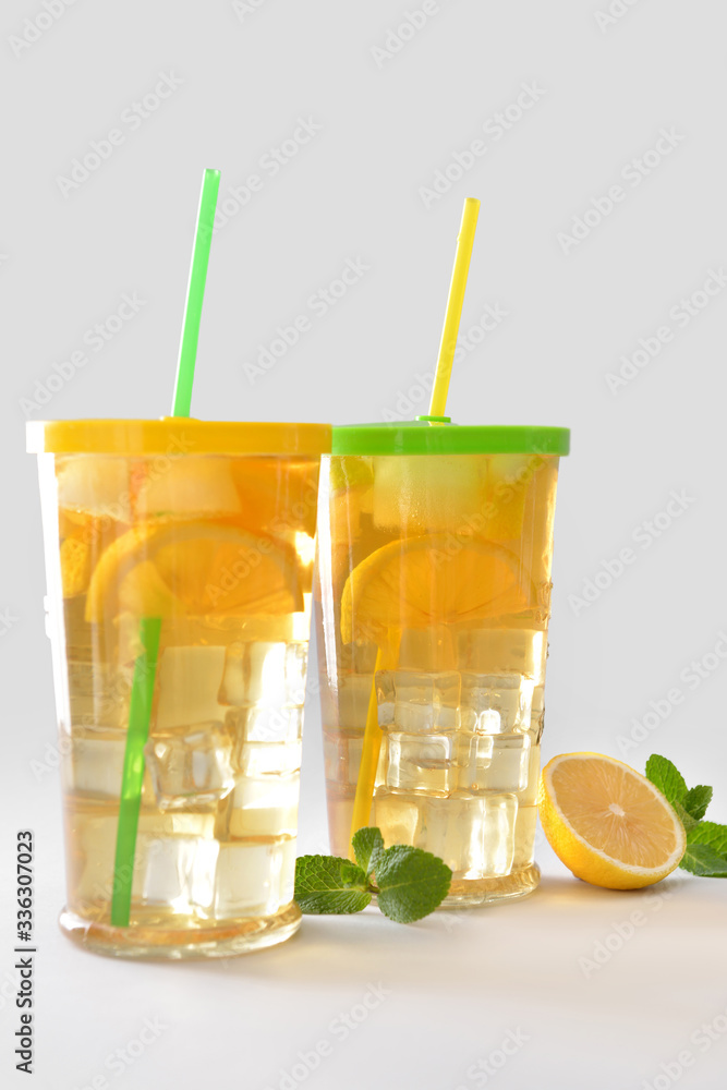 Glasses of tasty cold ice tea on grey background