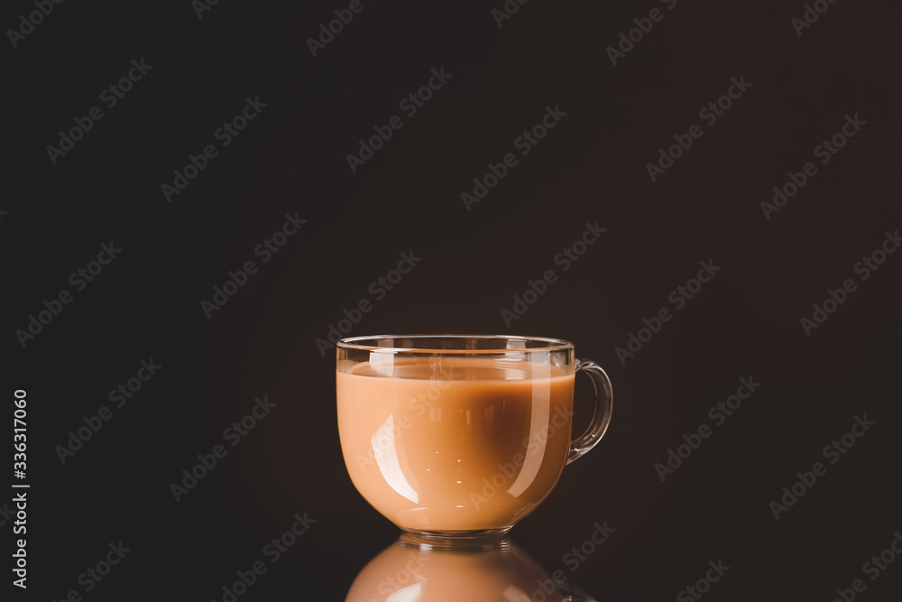 Glass cup with iced coffee on dark background