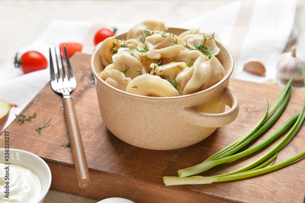 Pot with tasty dumplings on table