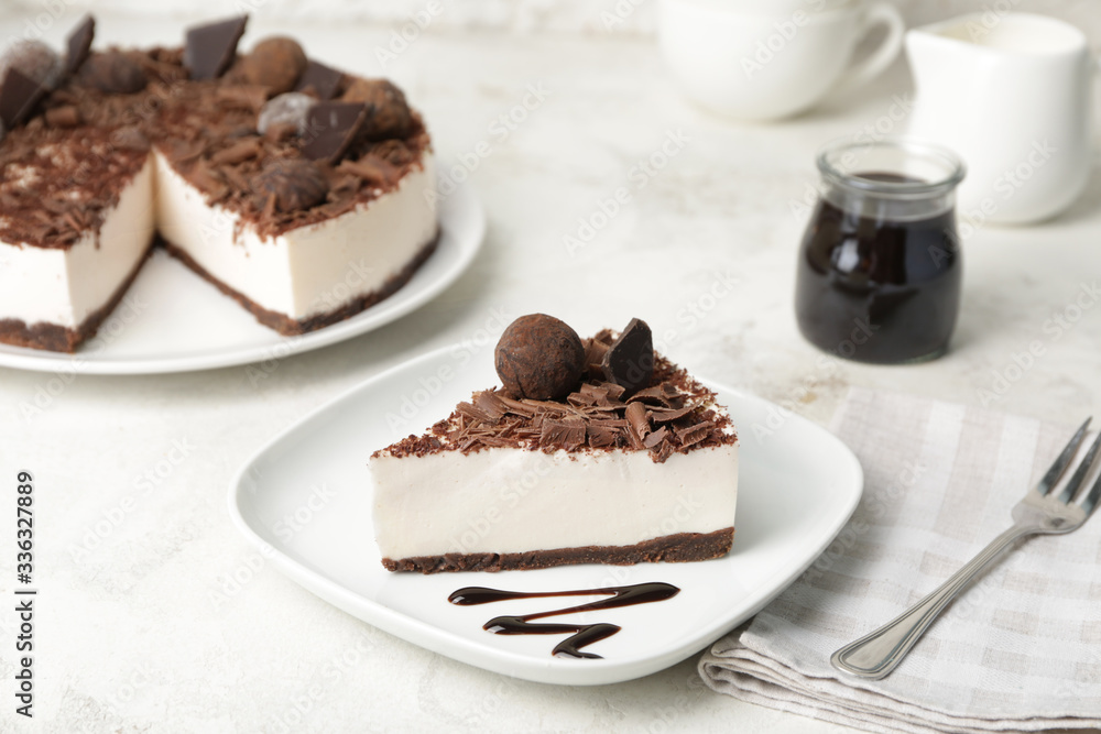 Plate with piece of chocolate cheesecake on table