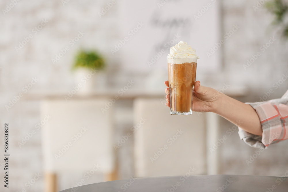 Woman with glass of tasty iced coffee in cafe