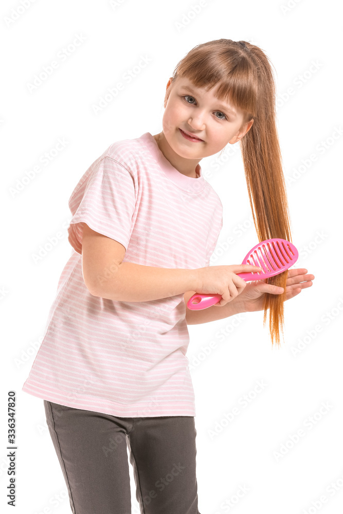 Little girl brushing hair on white background