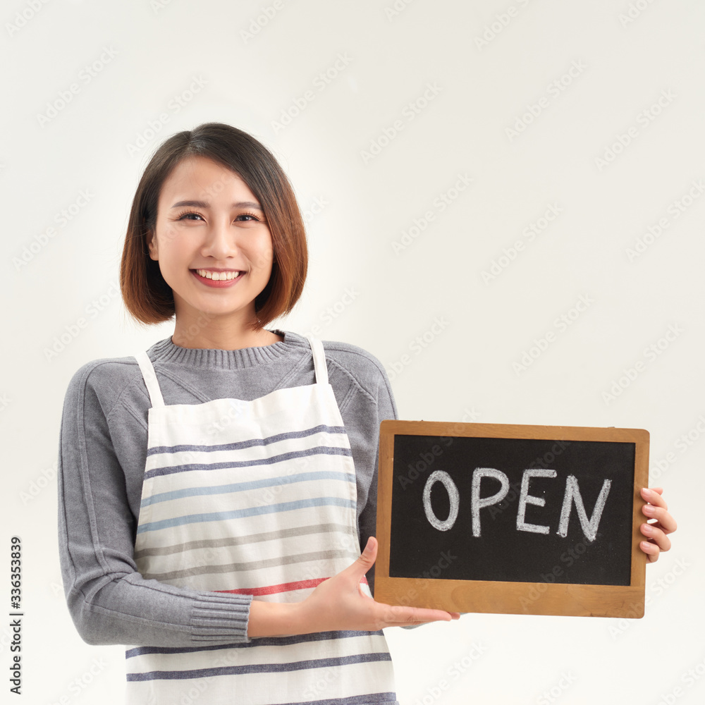 Female business owner holding OPEN sign on white