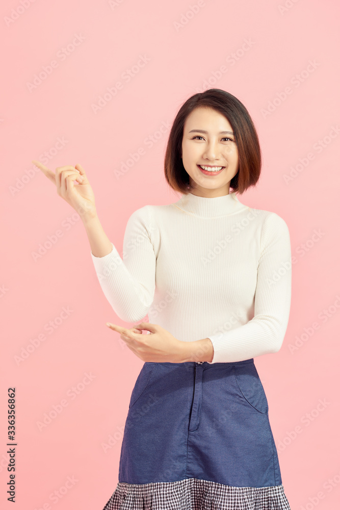 Businesswoman pressing button or something. Isolated on pink background