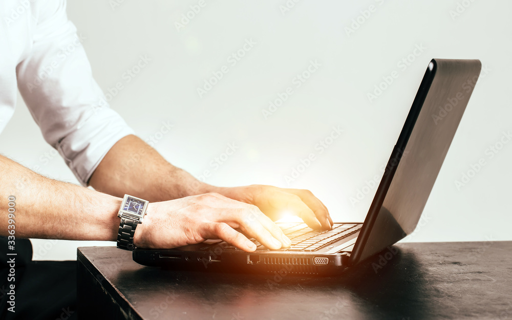 Male hands typing on laptop keyboard. Close-up